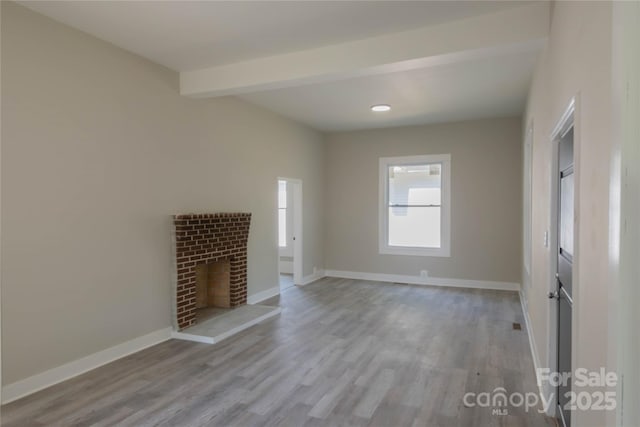 112 Hampton St, Chester, SC 29706 - unfurnished living room with wood finished floors, baseboards, a brick fireplace, and beamed ceiling
