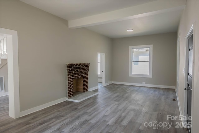 112 Hampton St, Chester, SC 29706 - unfurnished living room featuring wood finished floors, a fireplace, baseboards, and beam ceiling