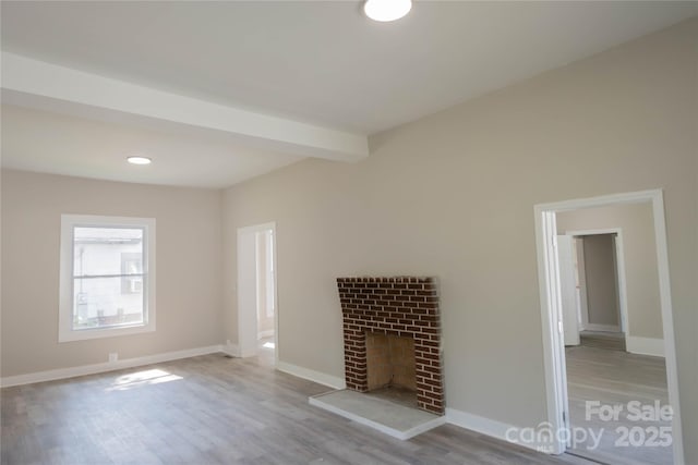112 Hampton St, Chester, SC 29706 - unfurnished living room with wood finished floors, baseboards, a brick fireplace, and beam ceiling