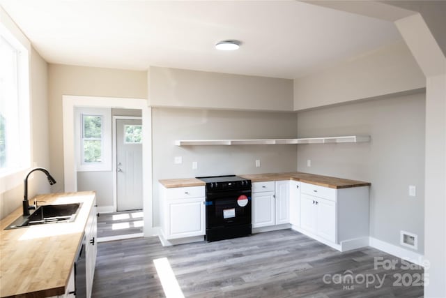 112 Hampton St, Chester, SC 29706 - kitchen featuring butcher block countertops, black range with electric cooktop, a sink, and wood finished floors