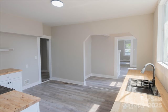 112 Hampton St, Chester, SC 29706 - kitchen with wood counters, a sink, white cabinets, light wood-style floors, and baseboards