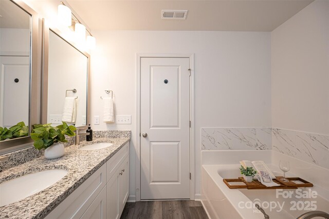 3403 Keith Dr, Charlotte, NC 28269 - bathroom featuring double vanity, a bath, and wood finished floors