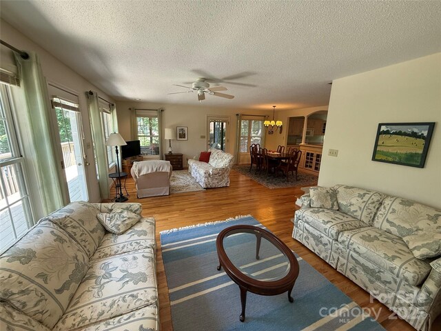 333 Lentz Landing Ln, Nebo, NC 28761 - living room featuring a textured ceiling, wood finished floors, ceiling fan, and a chandelier