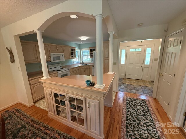 333 Lentz Landing Ln, Nebo, NC 28761 - kitchen featuring white appliances, decorative columns, light wood-style floors, arched walkways, and glass insert cabinets
