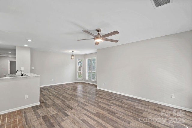 409 W 8th St Unit B, Charlotte, NC 28202 - unfurnished living room with wood finished floors, baseboards, ceiling fan, a sink, and recessed lighting