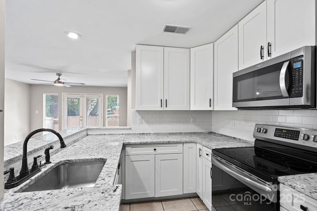 409 W 8th St Unit B, Charlotte, NC 28202 - kitchen with appliances with stainless steel finishes, a sink, backsplash, ceiling fan, and white cabinetry