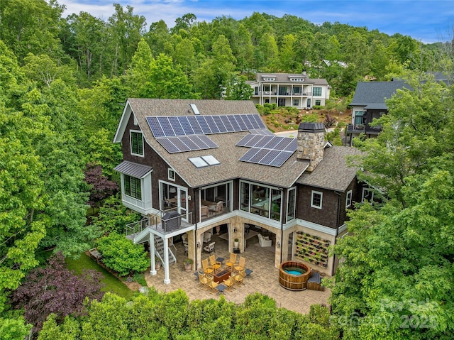 3 Bayonne Trl, Asheville, NC 28804 - back of property featuring a shingled roof, a patio, roof mounted solar panels, stairway, and an outdoor fire pit
