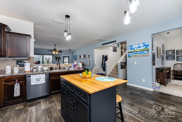 189 Fesperman Cir, Troutman, NC 28166 - kitchen featuring stainless steel dishwasher, a sink, butcher block countertops, a breakfast bar, and dark wood-type flooring