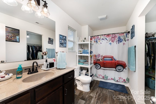 189 Fesperman Cir, Troutman, NC 28166 - bathroom featuring vanity, a walk in closet, toilet, and wood finished floors