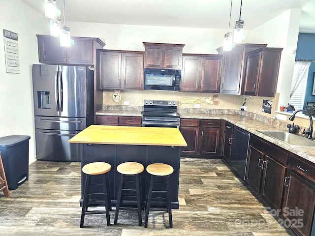 189 Fesperman Cir, Troutman, NC 28166 - kitchen with black microwave, electric stove, stainless steel fridge with ice dispenser, a kitchen breakfast bar, and a kitchen island