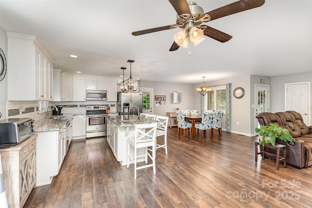 240 China Grove Rd, China Grove, NC 28123 - kitchen with appliances with stainless steel finishes, a breakfast bar, a chandelier, light stone countertops, and recessed lighting