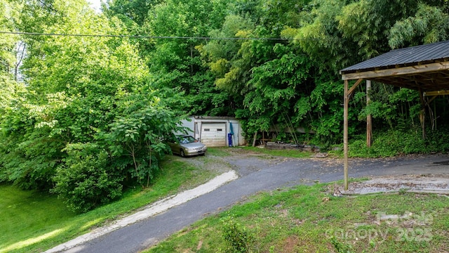 5366 Hayes Waters Rd, Morganton, NC 28655 - view of yard featuring an outbuilding, asphalt driveway, a detached garage, and a forest view