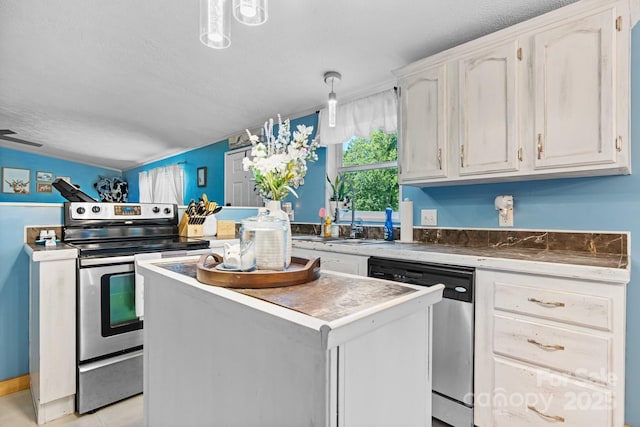 5366 Hayes Waters Rd, Morganton, NC 28655 - kitchen featuring appliances with stainless steel finishes, a kitchen island, a sink, decorative light fixtures, and a textured ceiling