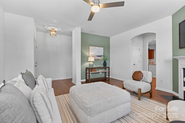 10027 Juniper Trace Dr, Charlotte, NC 28277 - living area featuring a ceiling fan, wood finished floors, arched walkways, a fireplace, and baseboards