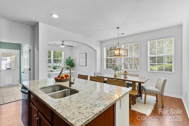 10027 Juniper Trace Dr, Charlotte, NC 28277 - kitchen with a sink, a chandelier, hanging light fixtures, stainless steel dishwasher, and light wood-style floors