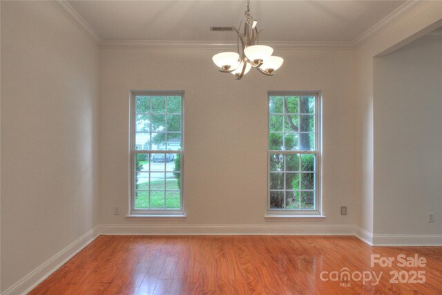 6310 Trevor Simpson Dr, Indian Trail, NC 28079 - spare room featuring a chandelier, light wood-type flooring, plenty of natural light, and crown molding