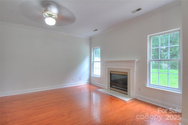 6310 Trevor Simpson Dr, Indian Trail, NC 28079 - unfurnished living room with light wood-style flooring, a premium fireplace, a ceiling fan, ornamental molding, and baseboards