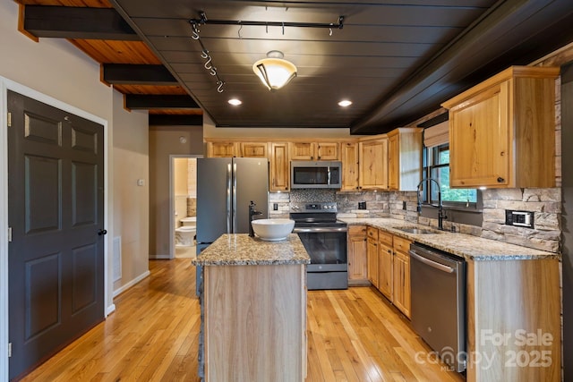 111 Grizzly Den Way, Marion, NC 28752 - kitchen with stainless steel appliances, a sink, light wood-style floors, a kitchen island, and decorative backsplash