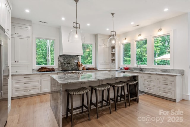 3020 Brooks Mill Ln, Wingate, NC 28174 - kitchen with a sink, backsplash, light stone countertops, light wood-type flooring, and recessed lighting