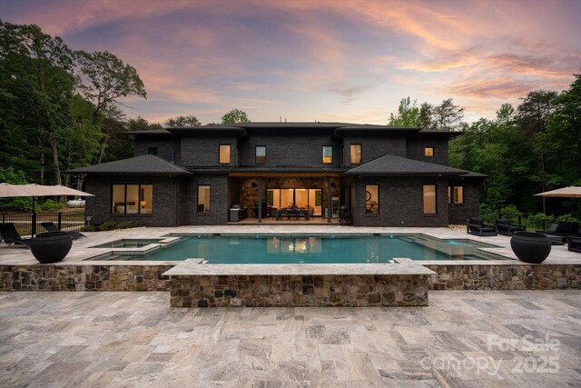 3020 Brooks Mill Ln, Wingate, NC 28174 - pool at dusk featuring a fire pit, a patio area, and a pool with connected hot tub