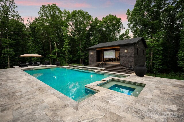 3020 Brooks Mill Ln, Wingate, NC 28174 - pool at dusk with a patio, an outbuilding, an exterior structure, and a pool with connected hot tub