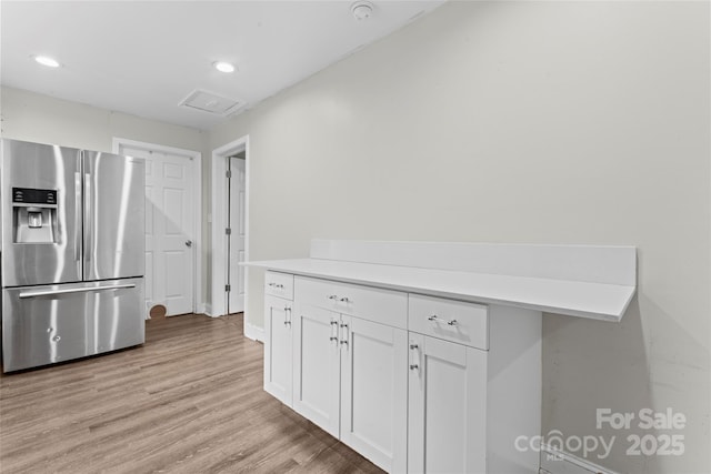 3400 Reid Ave, Charlotte, NC 28208 - kitchen featuring stainless steel fridge with ice dispenser, white cabinetry, light wood-style floors, recessed lighting, and light countertops