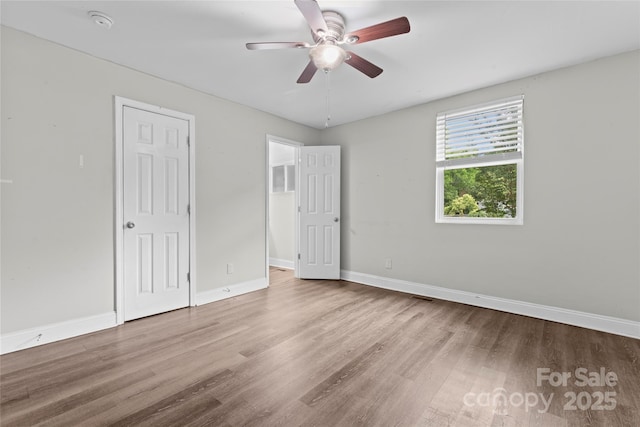 3400 Reid Ave, Charlotte, NC 28208 - unfurnished bedroom with wood finished floors, baseboards, a ceiling fan, and a closet