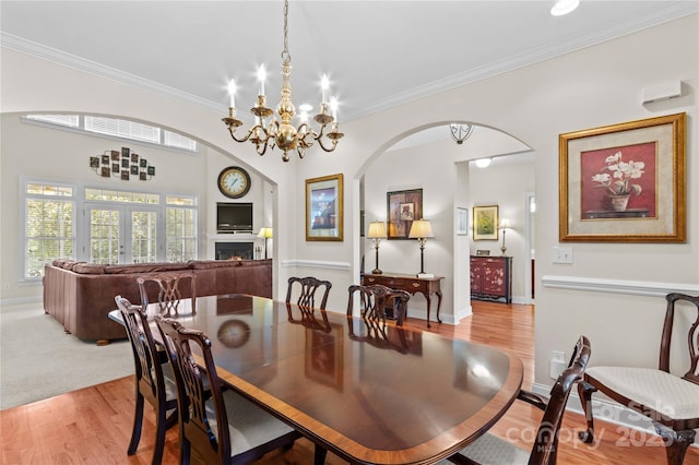 1070 Blueberry Rd, Salisbury, NC 28147 - dining area featuring ornamental molding, arched walkways, light wood-style flooring, a chandelier, and baseboards