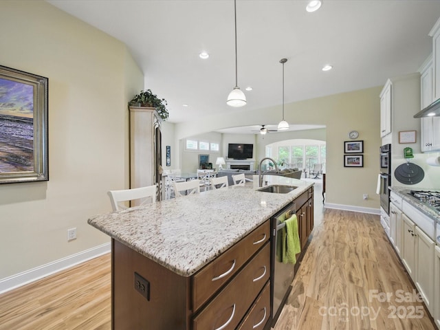 1004 Fairbanks Ct, Indian Trail, NC 28079 - kitchen with a kitchen island with sink, ceiling fan, a sink, dishwasher, and light wood-style flooring