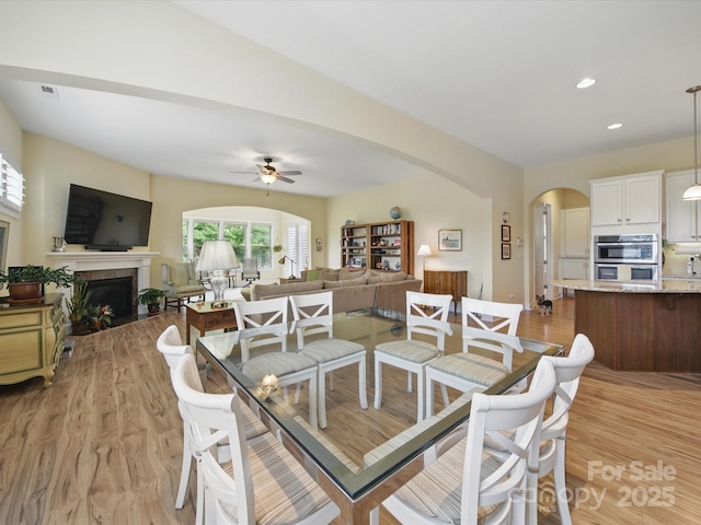 1004 Fairbanks Ct, Indian Trail, NC 28079 - dining area featuring arched walkways, ceiling fan, light wood finished floors, a fireplace with flush hearth, and recessed lighting