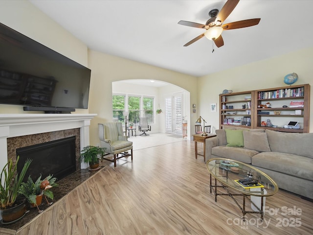 1004 Fairbanks Ct, Indian Trail, NC 28079 - living area with arched walkways, a high end fireplace, a ceiling fan, and wood finished floors