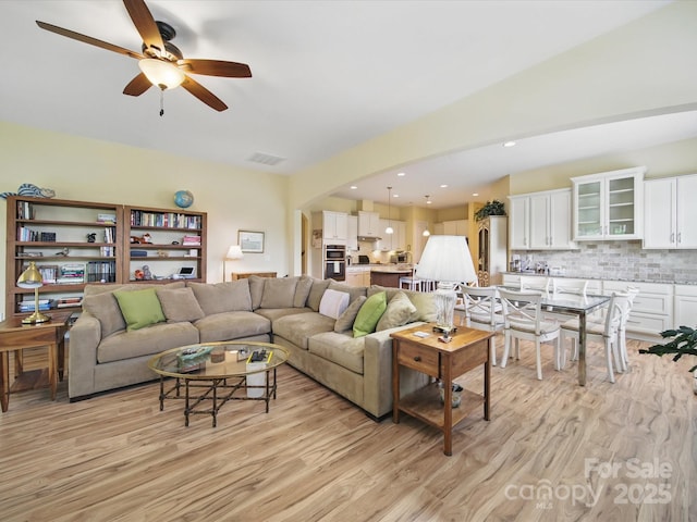 1004 Fairbanks Ct, Indian Trail, NC 28079 - living area with light wood-style flooring, a ceiling fan, and arched walkways