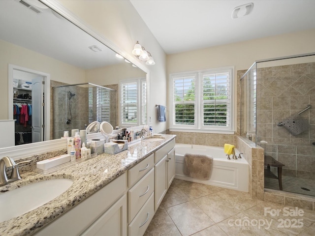 1004 Fairbanks Ct, Indian Trail, NC 28079 - bathroom featuring a shower stall, double vanity, a bath, tile patterned floors, and a walk in closet