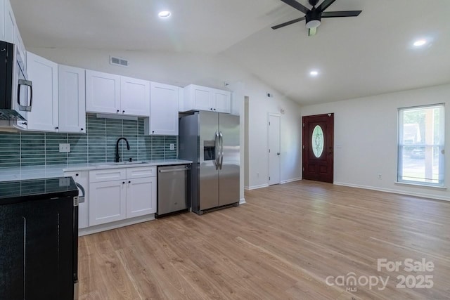 5233 Great Wagon Rd, Charlotte, NC 28215 - kitchen with appliances with stainless steel finishes, a sink, vaulted ceiling, ceiling fan, and tasteful backsplash