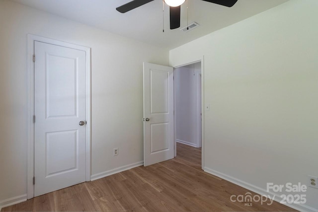 5233 Great Wagon Rd, Charlotte, NC 28215 - unfurnished bedroom with wood finished floors, baseboards, and a ceiling fan