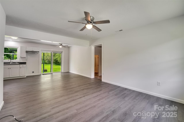 285 Painter Rd S, Cullowhee, NC 28723 - unfurnished living room featuring ceiling fan, dark wood-style flooring, baseboards, and a sink