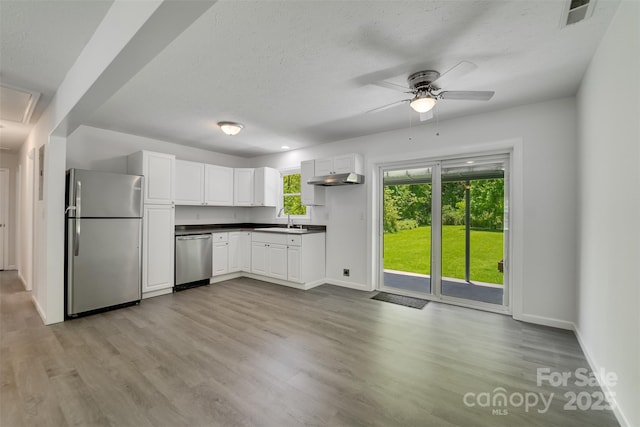 285 Painter Rd S, Cullowhee, NC 28723 - kitchen featuring appliances with stainless steel finishes, a sink, dark countertops, baseboards, and light wood-style flooring