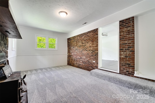 285 Painter Rd S, Cullowhee, NC 28723 - unfurnished living room with carpet floors, a textured ceiling, a wainscoted wall, and brick wall