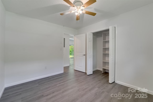 285 Painter Rd S, Cullowhee, NC 28723 - unfurnished bedroom featuring wood finished floors, baseboards, a ceiling fan, and a closet