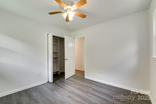 285 Painter Rd S, Cullowhee, NC 28723 - unfurnished bedroom with wood finished floors, baseboards, a closet, and ceiling fan