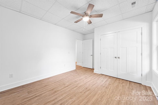 2027 Marquesas Ave, Tega Cay, SC 29708 - unfurnished bedroom featuring a drop ceiling, light wood finished floors, a closet, and a ceiling fan