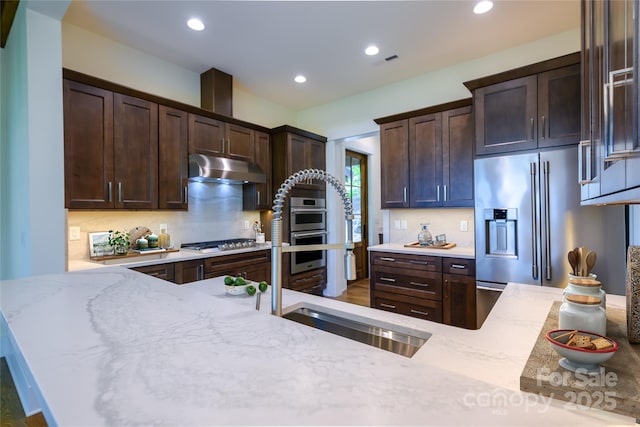 615 Macallan Dr Unit 321, Waynesville, NC 28786 - kitchen featuring under cabinet range hood, stainless steel appliances, dark brown cabinetry, light stone counters, and recessed lighting