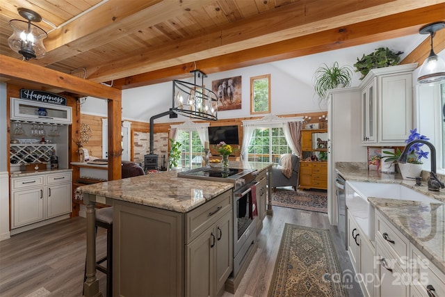 334 Arbra Mountain Way, Bostic, NC 28018 - kitchen with a wood stove, appliances with stainless steel finishes, a sink, a center island, and open floor plan