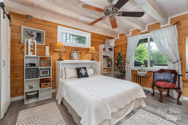334 Arbra Mountain Way, Bostic, NC 28018 - bedroom featuring wood finished floors, wooden ceiling with exposed beams, wood walls, a barn door, and a ceiling fan