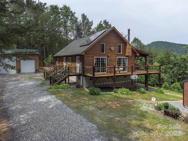 334 Arbra Mountain Way, Bostic, NC 28018 - view of front facade featuring an outdoor structure, roof mounted solar panels, a garage, a deck with mountain view, and crawl space