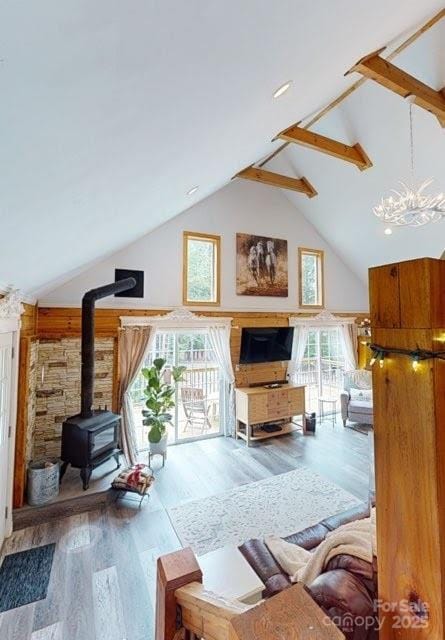 334 Arbra Mountain Way, Bostic, NC 28018 - living room featuring high vaulted ceiling, a wood stove, wood finished floors, and beam ceiling