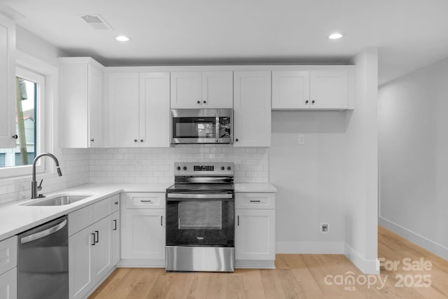 101 Churchill Dr, Kings Mountain, NC 28086 - kitchen with stainless steel appliances, a sink, white cabinetry, light countertops, and recessed lighting
