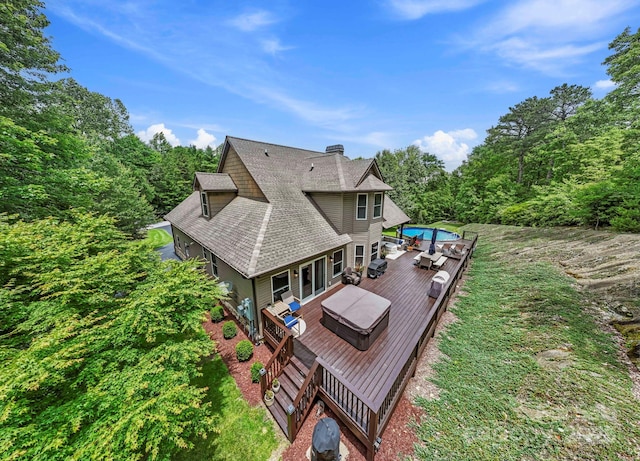 21 School House Rd, Pisgah Forest, NC 28768 - rear view of house featuring a wooden deck, a shingled roof, a chimney, and a wooded view