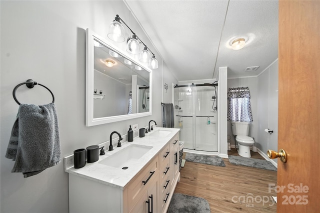 2291 Howell Rd, Midland, NC 28107 - bathroom featuring double vanity, a stall shower, wood finished floors, and a textured ceiling