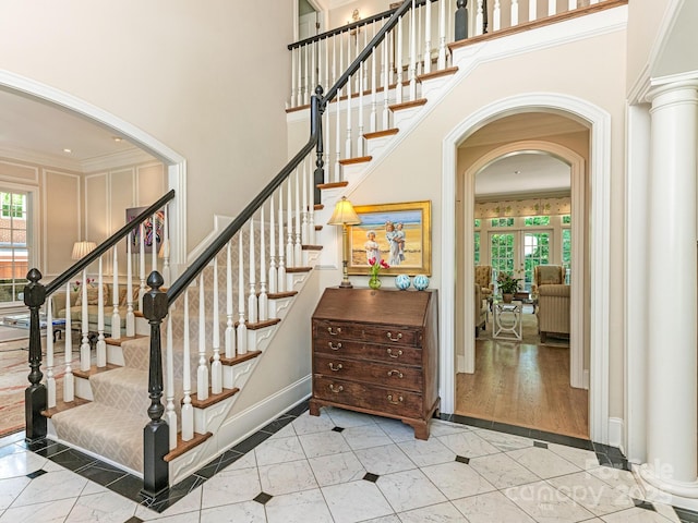 2516 Selwyn Ave, Charlotte, NC 28209 - staircase featuring inlaid floor details, plenty of natural light, baseboards, a towering ceiling, and crown molding